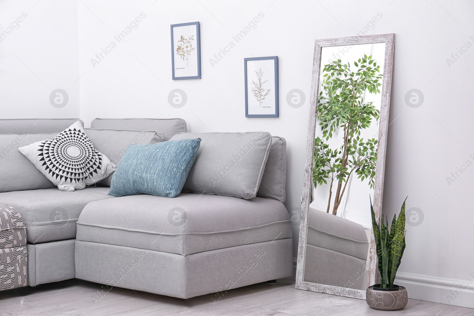 Photo of Elegant room interior with large mirror and sectional couch