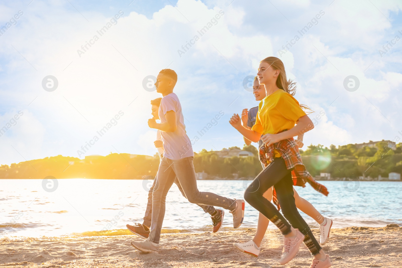 Image of School holidays. Group of happy children running on beach