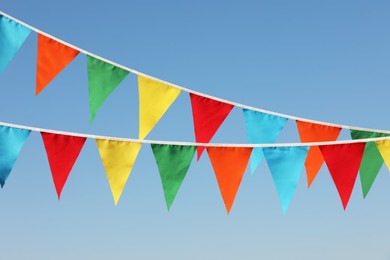 Photo of Buntings with colorful triangular flags against blue sky