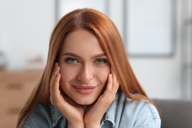 Photo of Portrait of beautiful young woman with red hair indoors. Attractive happy lady looking into camera. Space for text