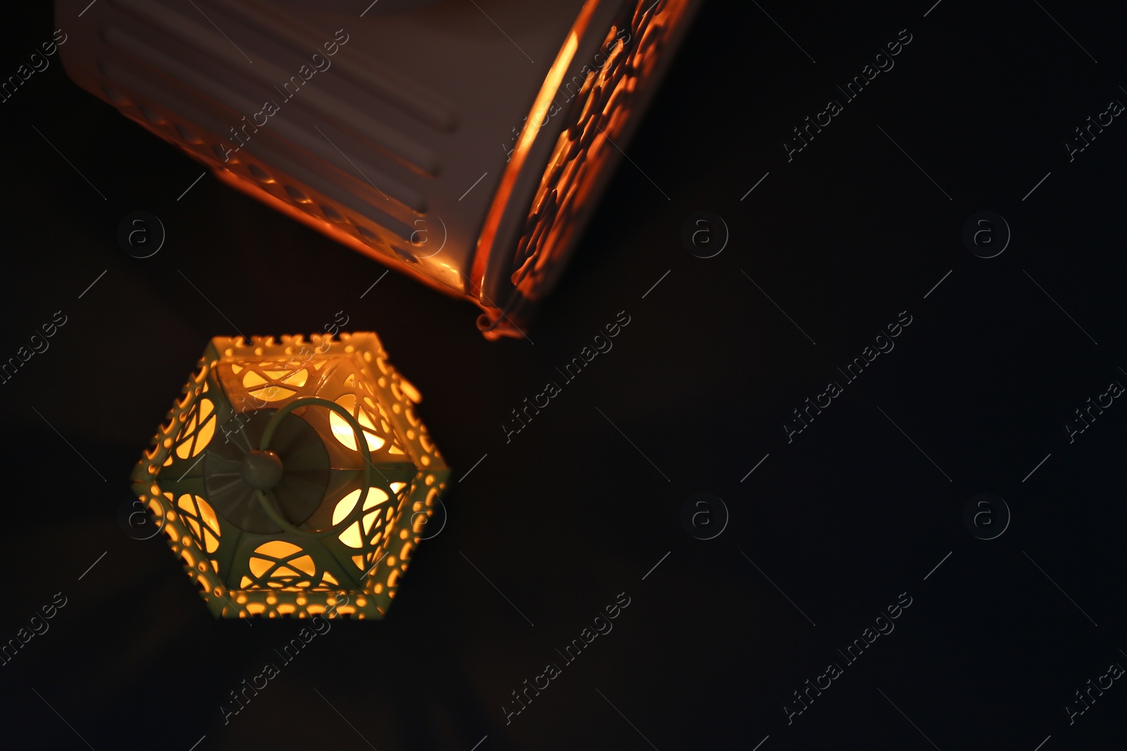 Photo of Decorative Arabic lanterns in darkness, flat lay. Space for text