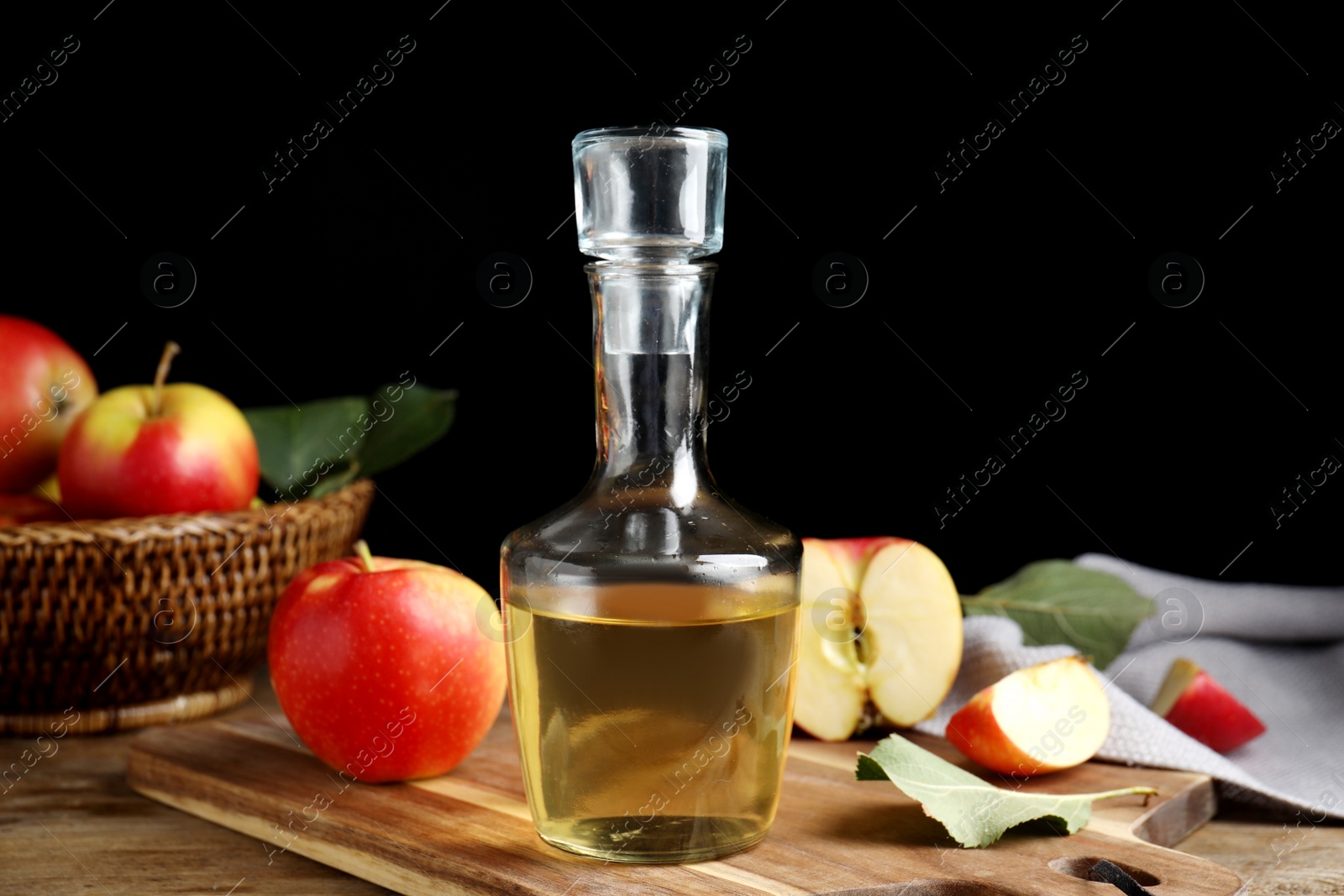 Photo of Natural apple vinegar and fresh fruits on wooden table