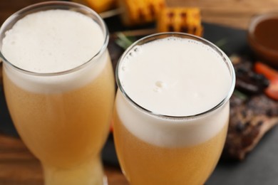 Glasses of tasty beer on table, closeup view