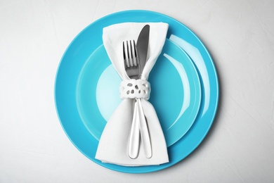 Photo of Plates with cutlery and napkin on light background, top view. Festive dinner setting