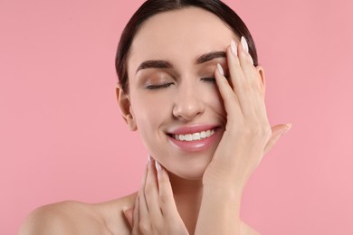 Portrait of beautiful young woman on pink background