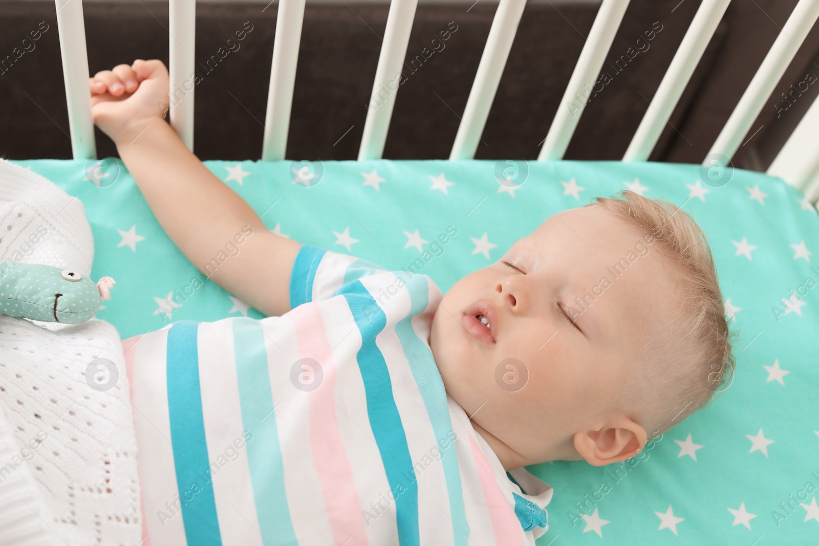 Photo of Cute little child sleeping in crib at home