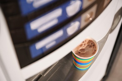 Coffee vending machine with paper cup on drip tray, above view