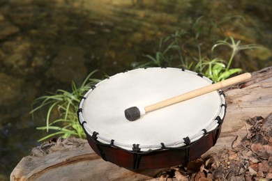 Modern drum and drumstick on stump outdoors. Percussion musical instrument