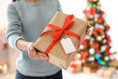 Young woman with Christmas gift at home