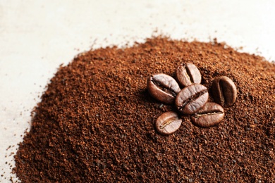 Photo of Coffee grounds and roasted beans on table, closeup