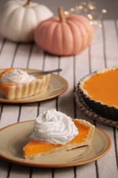 Photo of Piece of fresh homemade pumpkin pie with whipped cream on table