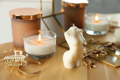 Photo of Beautiful female body shaped candle on wooden table. Stylish decor