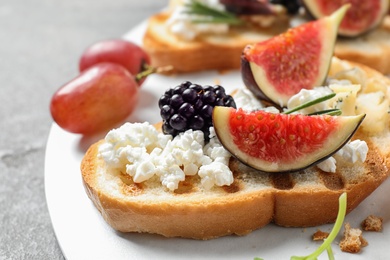 Photo of Bruschettas with cheese, figs and blackberry served on table, closeup