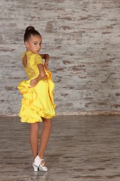 Beautifully dressed little girl dancing in studio