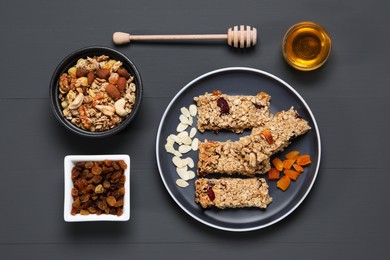 Tasty granola bars and ingredients on grey wooden table, flat lay