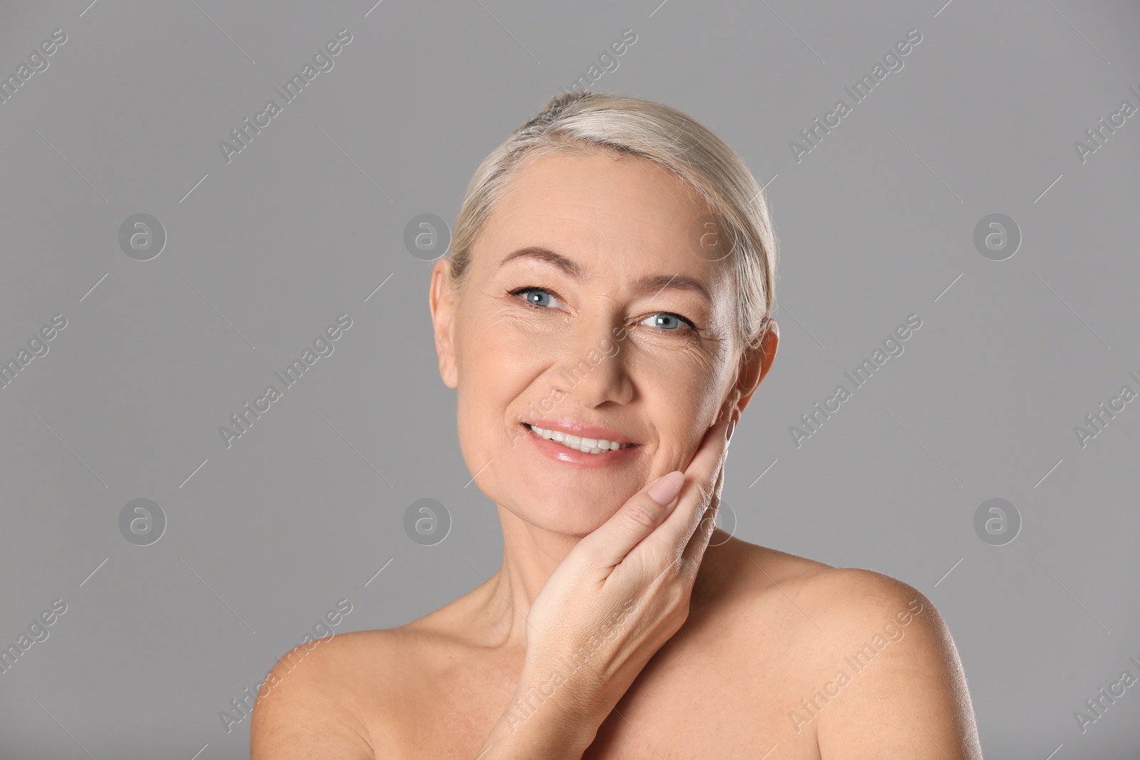 Photo of Portrait of beautiful mature woman on grey background