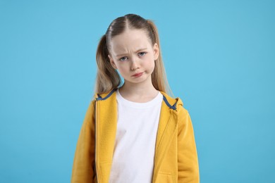 Photo of Portrait of sad girl on light blue background