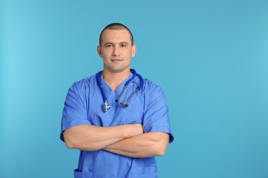 Portrait of medical assistant with stethoscope on color background