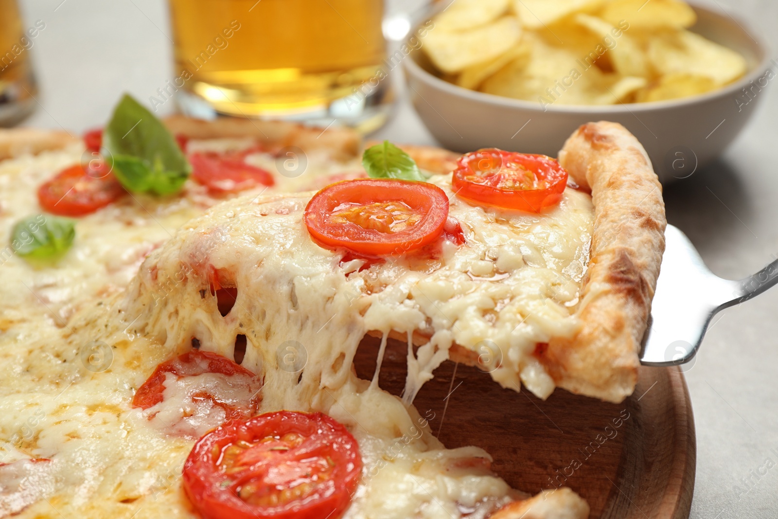 Photo of Taking slice of delicious pizza Margherita at table, closeup