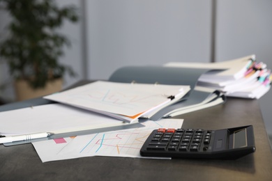 Folders with documents and calculator on office table