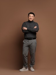 Photo of Full length portrait of happy man on brown background. Space for text