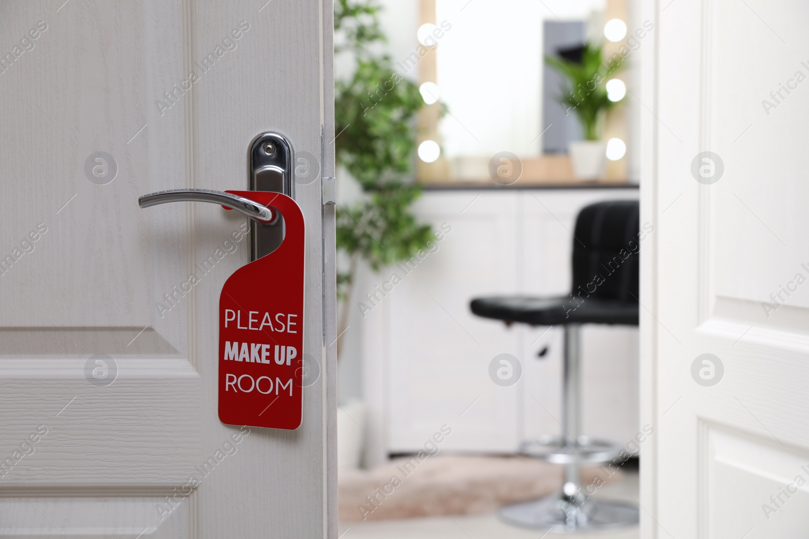 Photo of Open door with sign PLEASE MAKE UP ROOM on handle at hotel