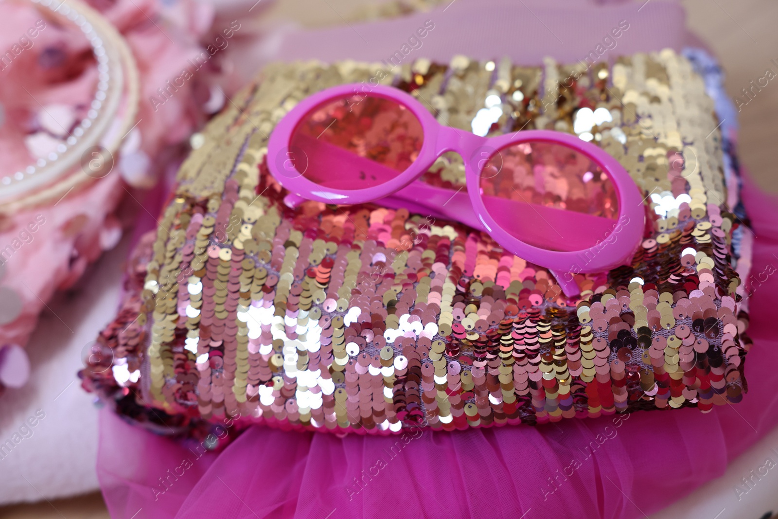 Photo of Stylish carnival costume with sequins and sunglasses, closeup