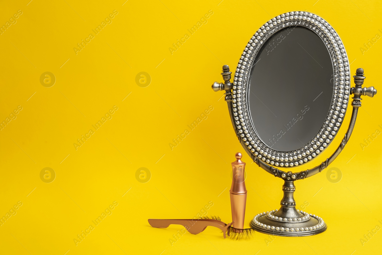 Photo of Magnetic eyelashes and accessories on yellow background. Space for text