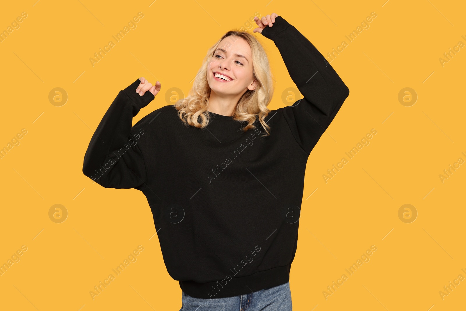 Photo of Happy woman in stylish warm sweater on orange background