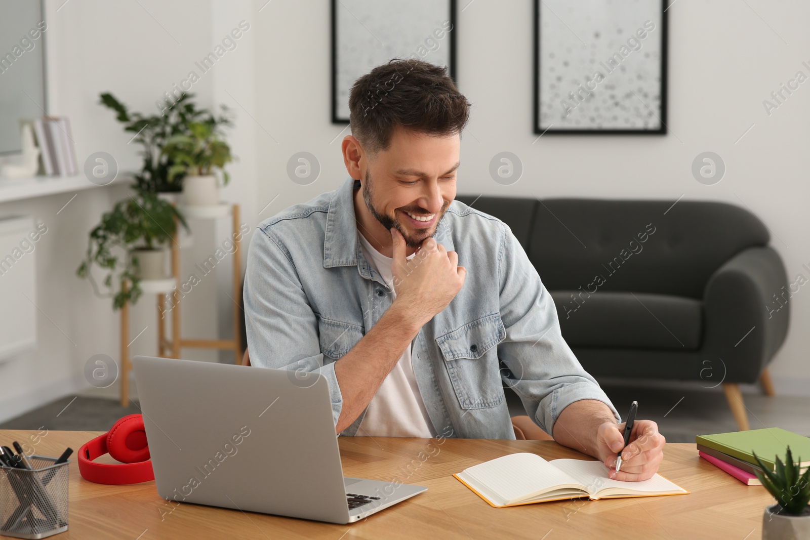 Photo of Online translation course. Man writing near laptop at home