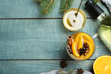 Photo of Aromatic mulled wine on light blue wooden table, flat lay. Space for text