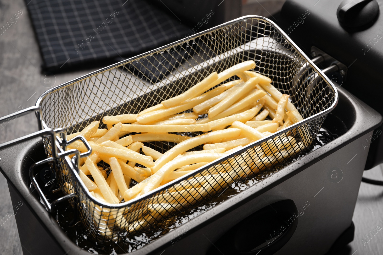 Photo of Cooking delicious french fries in hot oil