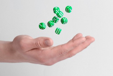 Photo of Man throwing game dices on white background, closeup