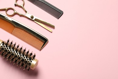 Photo of Professional hair dresser tools on pink background, flat lay. Space for text