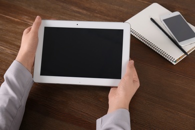 Photo of Woman using tablet at table, closeup with space for design