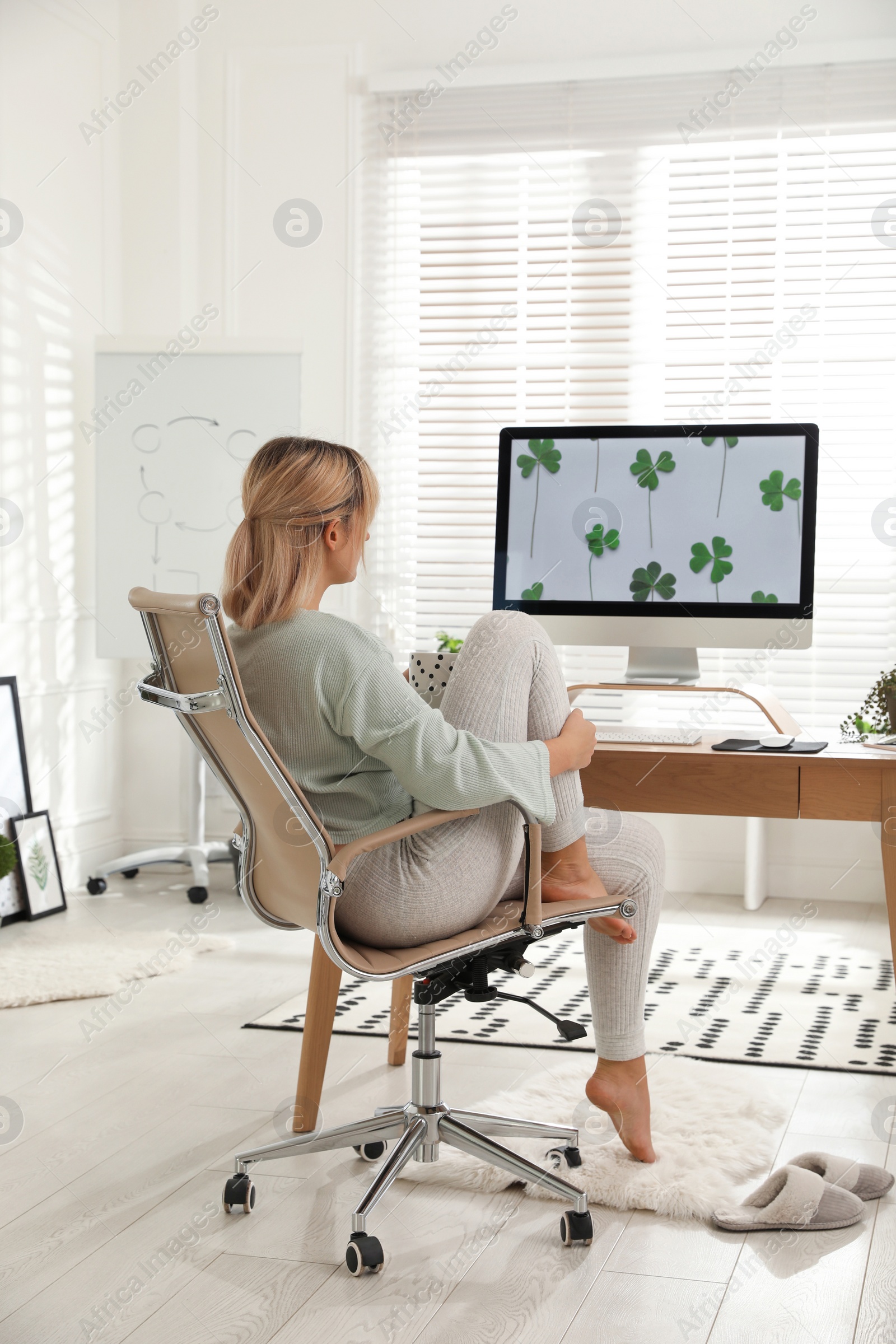 Photo of Woman with cup of tea at table in light room. Home office