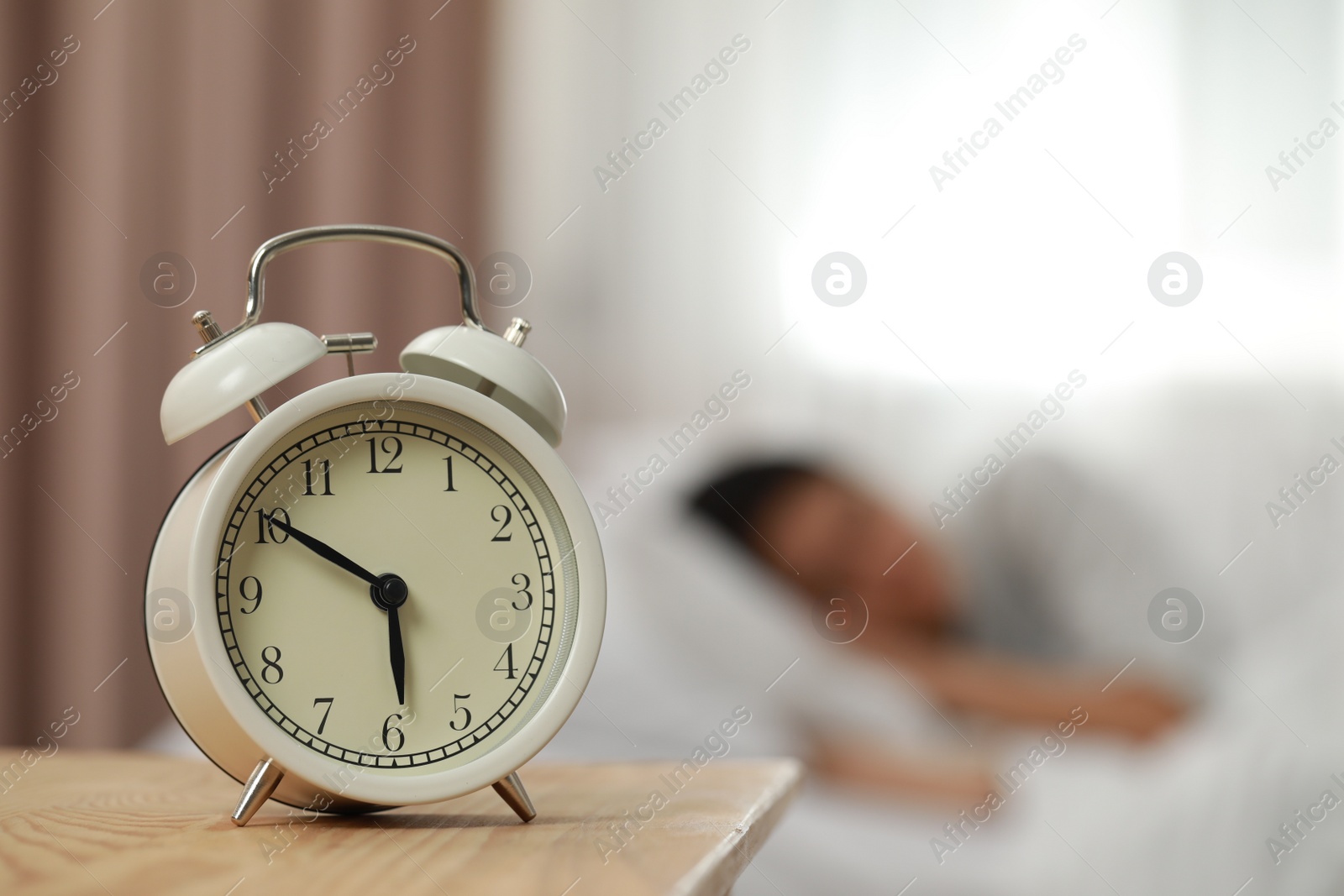 Photo of Woman sleeping in bedroom, focus on alarm clock. Space for text