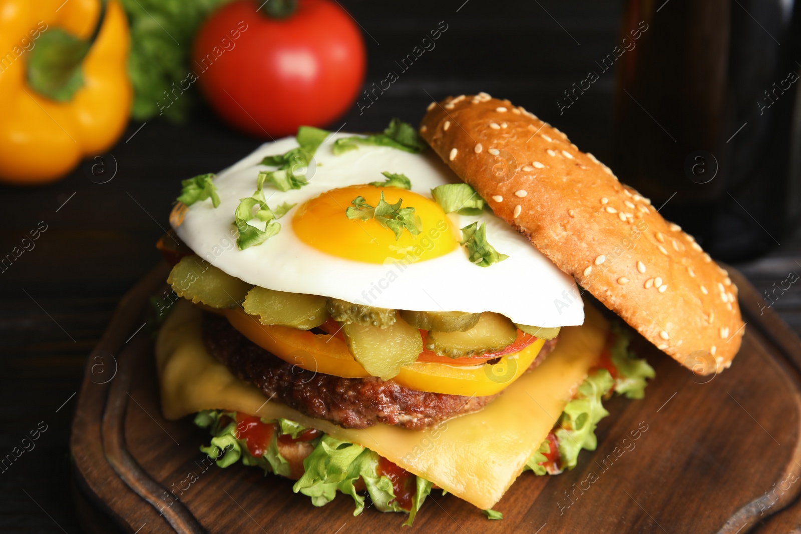 Photo of Tasty burger with fried egg on wooden board