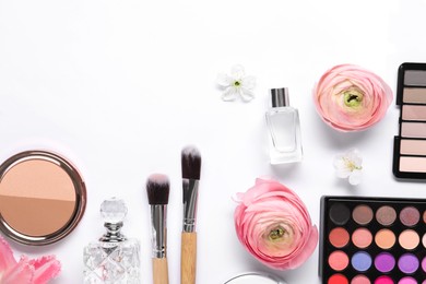 Flat lay composition with different makeup products and beautiful spring flowers on white background, space for text