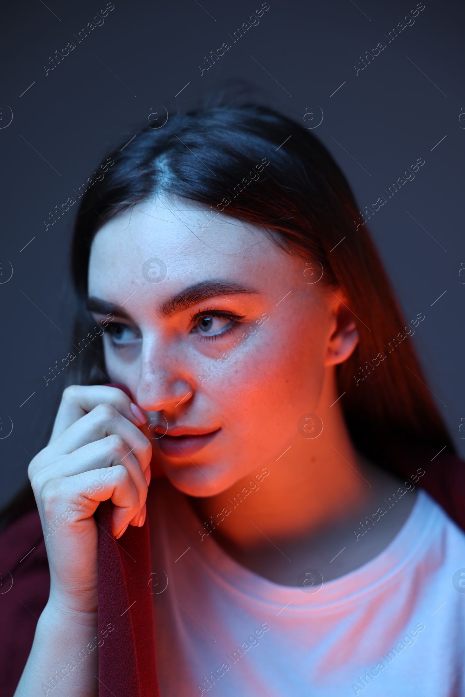 Photo of Portrait of beautiful woman on dark blue background in neon lights