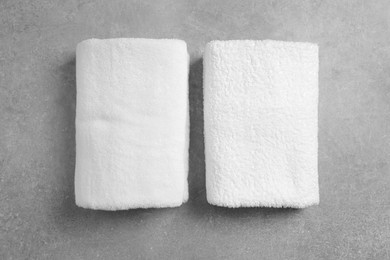 Photo of Soft folded towels on gray background, flat lay
