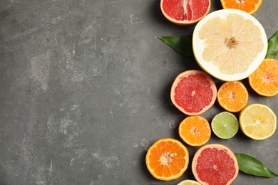 Photo of Different citrus fruits on grey background, top view. Space for text