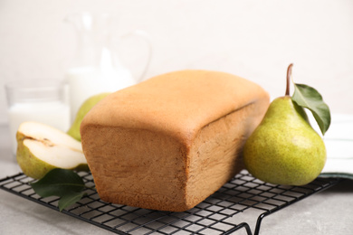 Photo of Tasty bread and pears on light grey table, closeup. Homemade cake