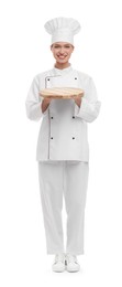 Photo of Happy chef in uniform holding empty wooden board on white background