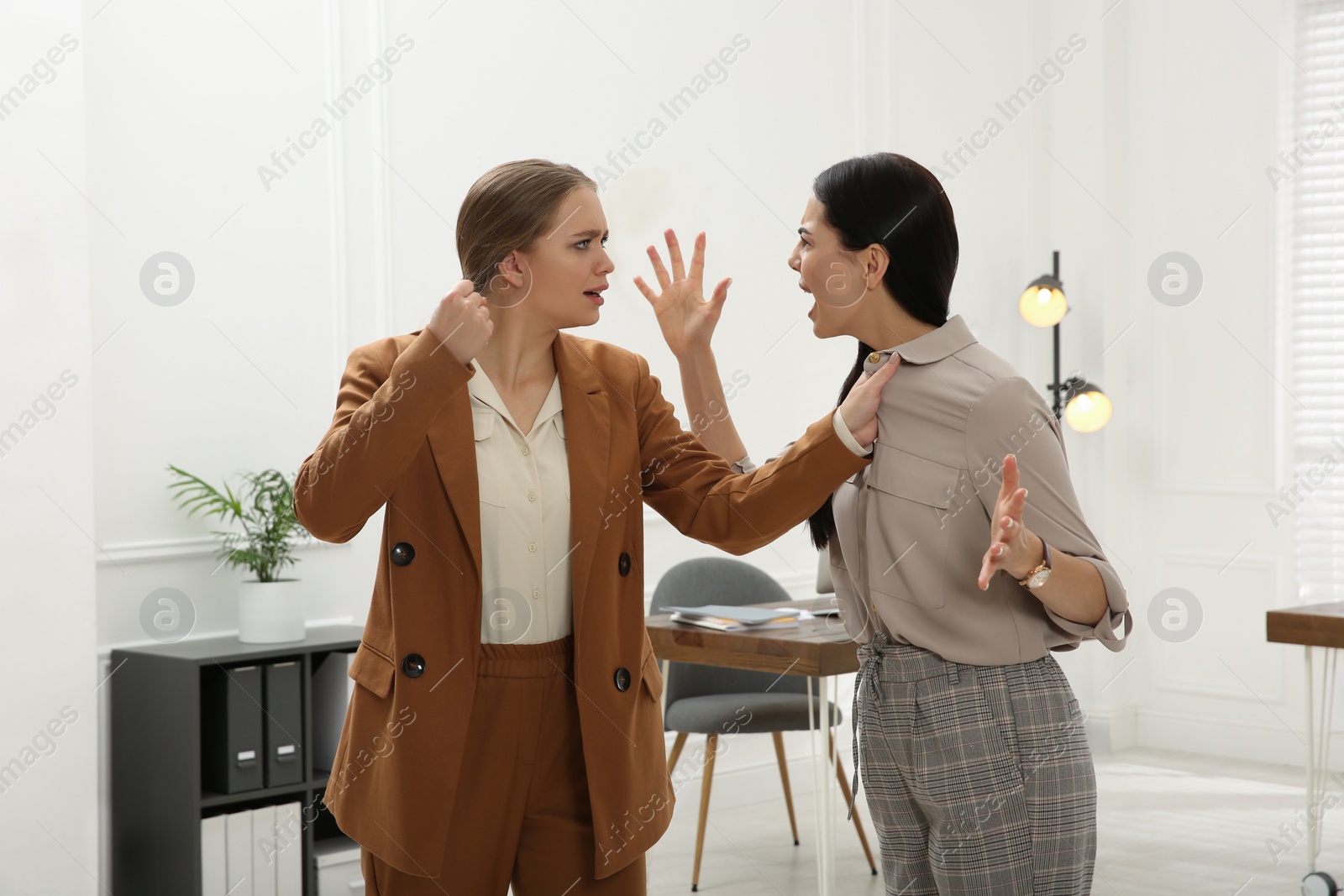 Photo of Emotional colleagues fighting in office. Workplace conflict