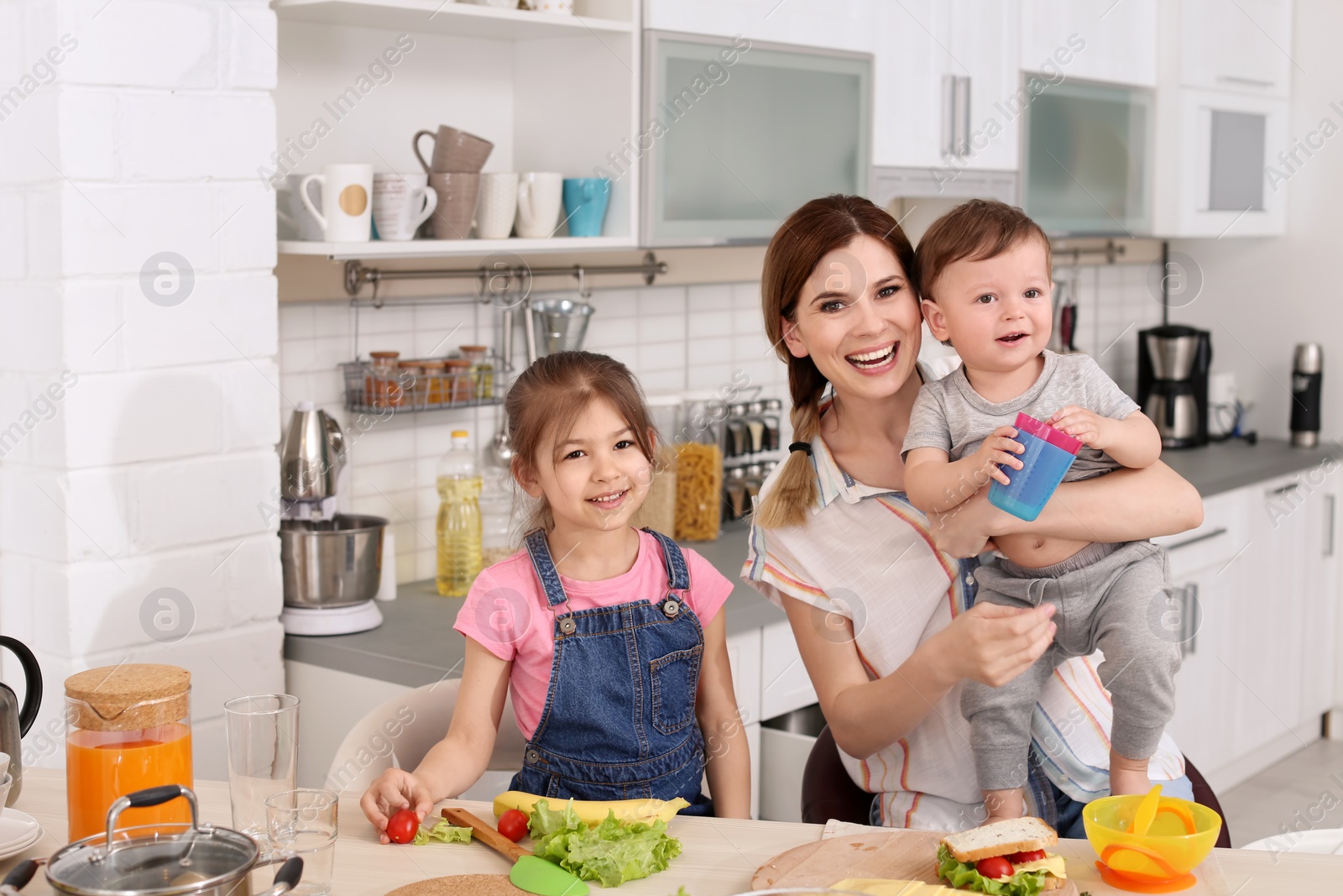 Photo of Housewife preparing dinner with her children on kitchen