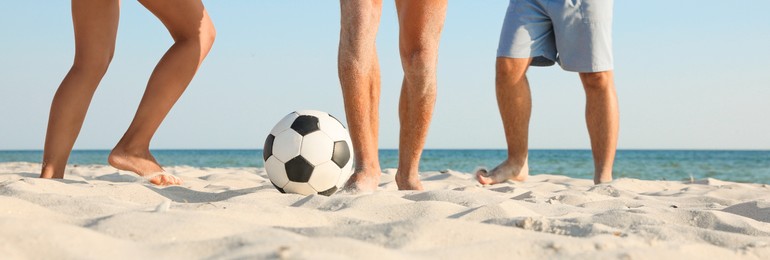 Image of Group of friends playing football on sandy beach, closeup. Banner design