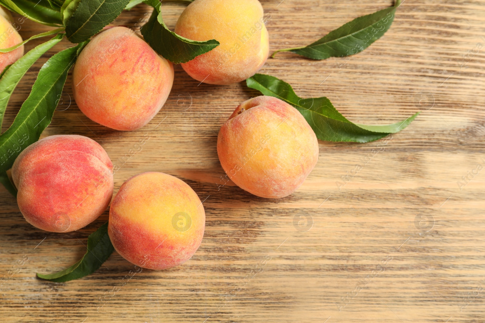 Photo of Fresh sweet peaches on wooden table, top view