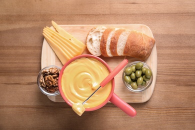 Photo of Flat lay composition with cheese fondue and products on wooden table