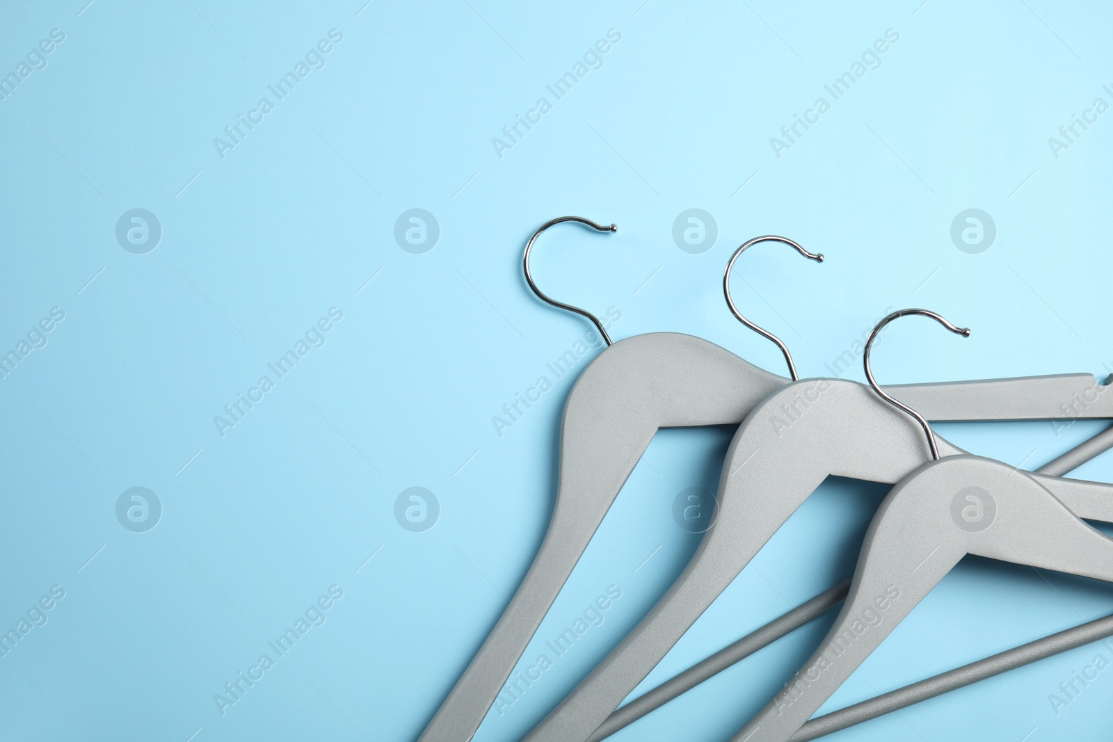 Photo of Flat lay composition with empty hangers on color background. Space for text